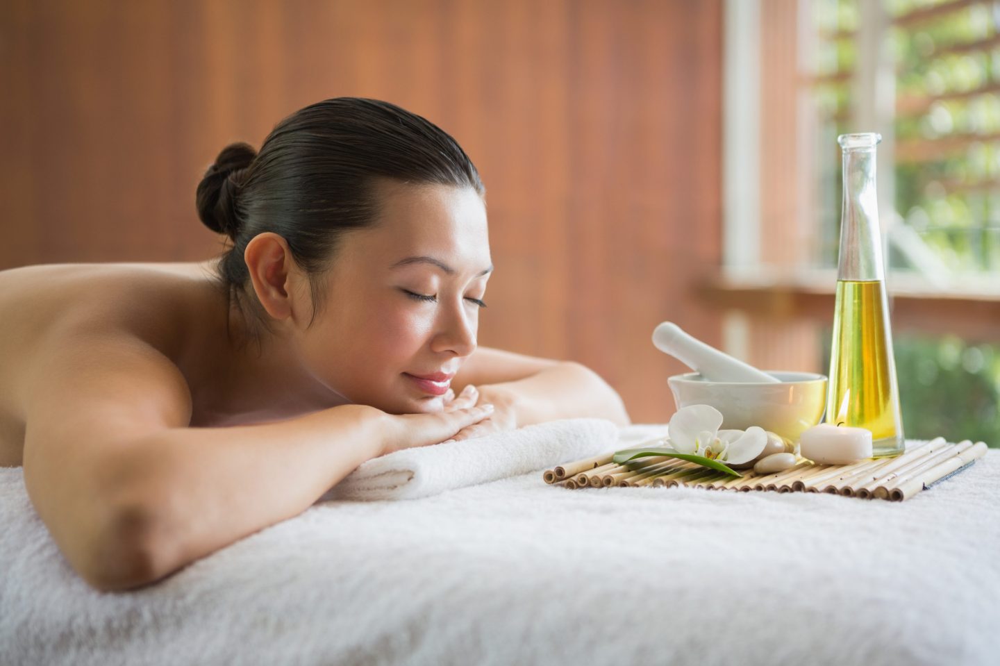 Seorang wanita sedang rileks dipijat dengan minyak.