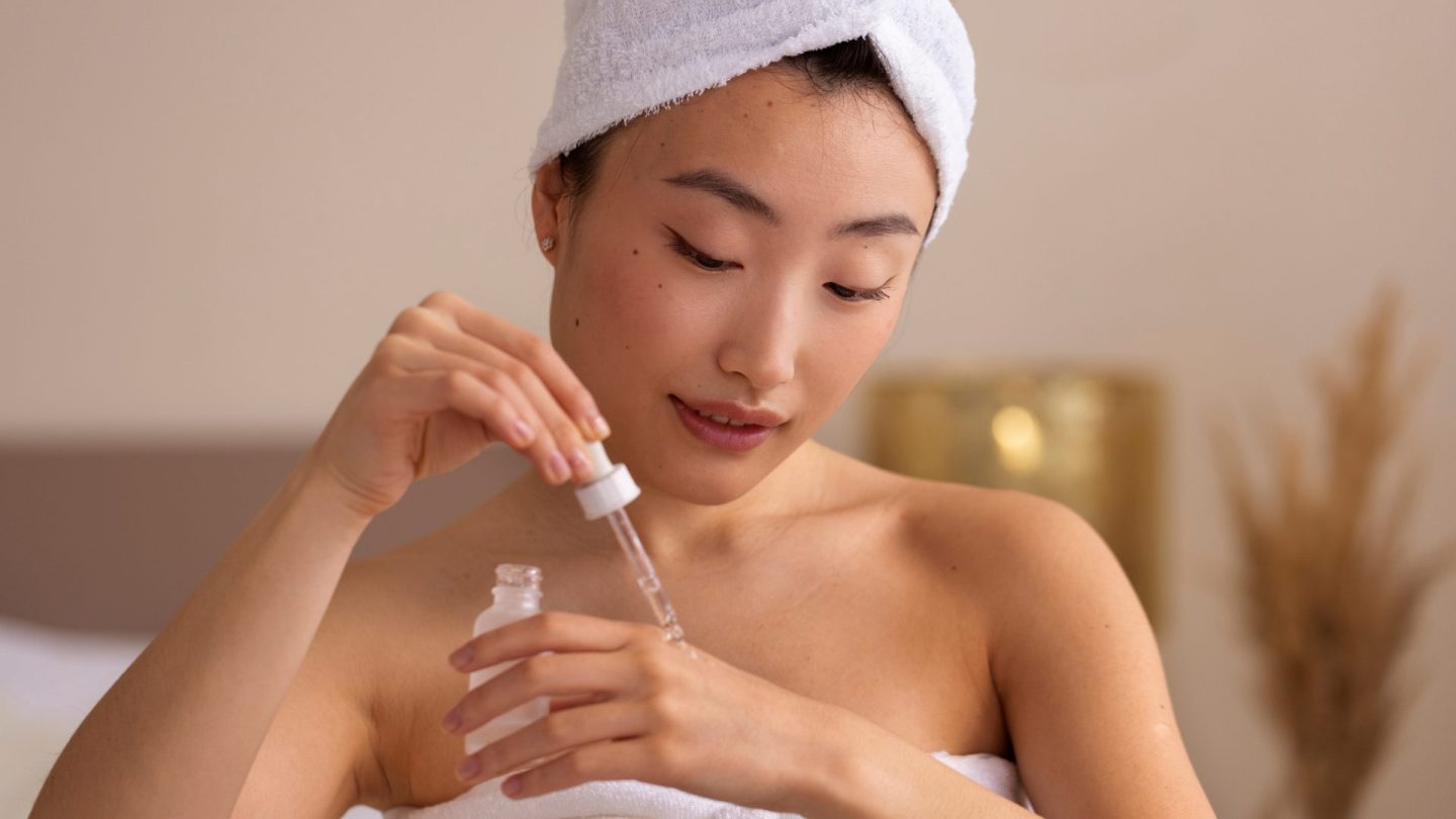 Seorang wanita meneteskan beberapa minyak menggunakan pinset