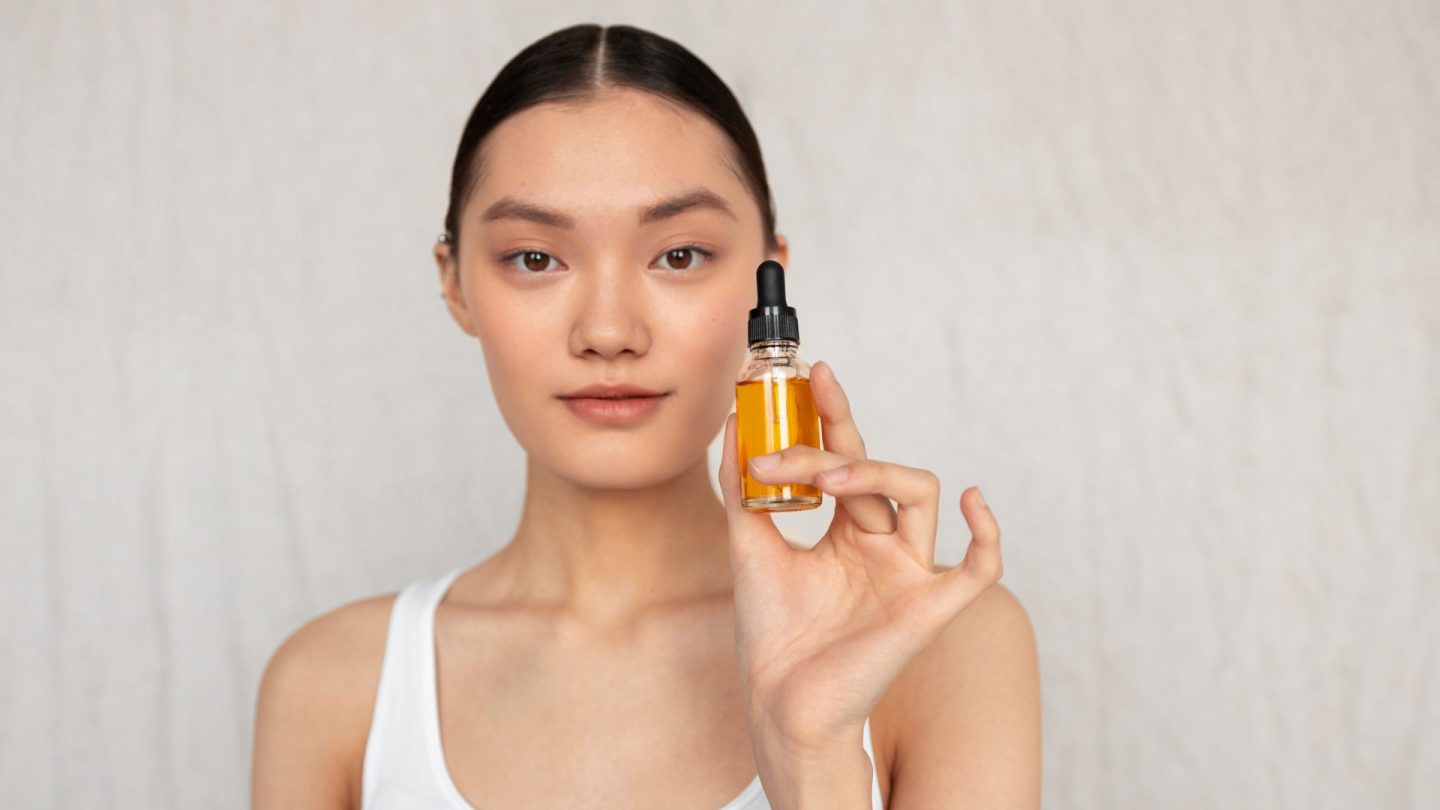 Seorang wanita sambil memegang sebotol minyak