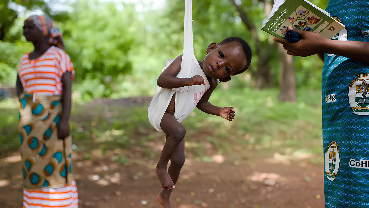 bayi afrika yang sedang ditimbang untuk dinilai berat badannya
